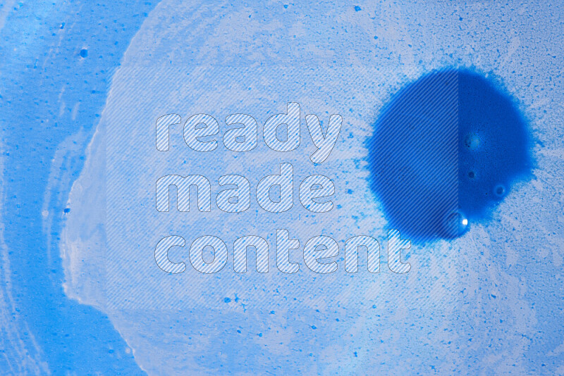 تلتقط الصورة تناثرا للطلاء الأزرق علي خلفية زرقاء