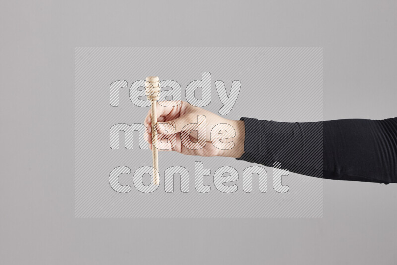 A woman in black abaya holding different wooden essentials in different positions