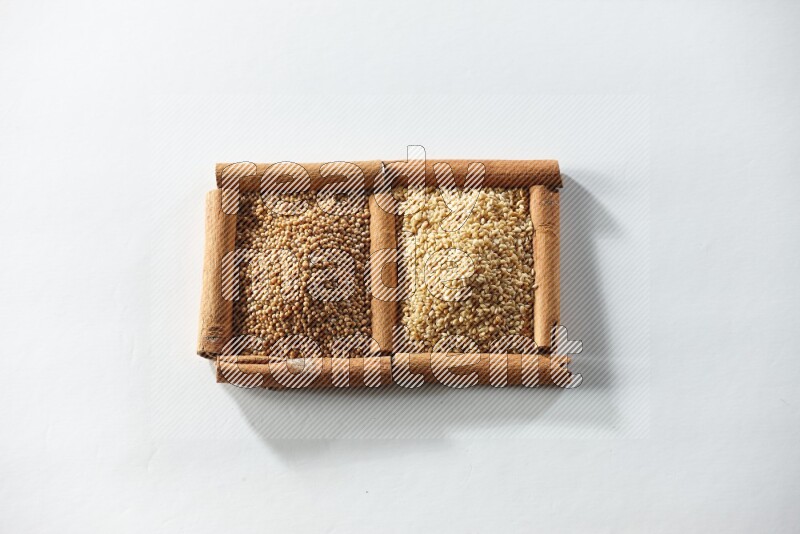 2 squares of cinnamon sticks full of mustard seeds and sesame on white flooring