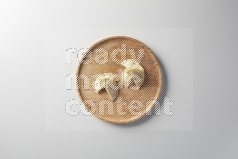 Five Sambosas on a wooden round plate on a white background