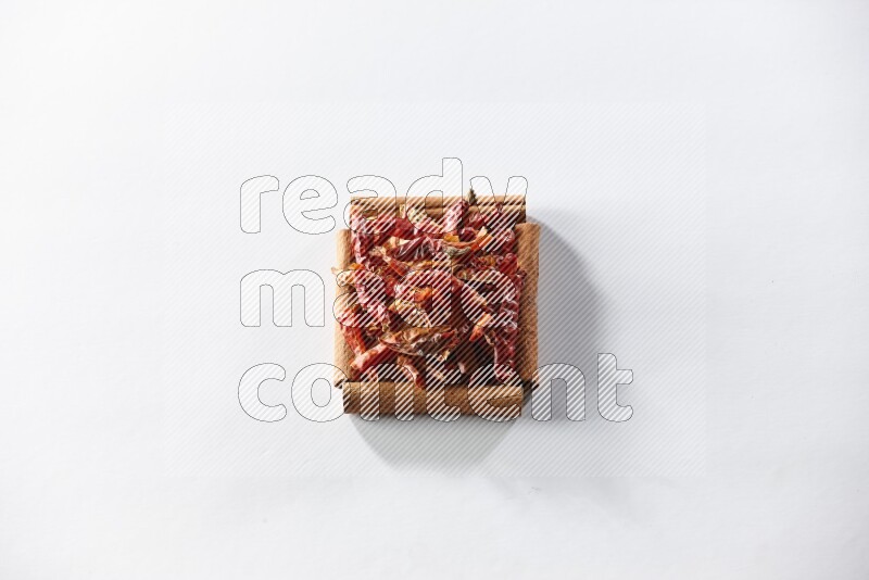 A single square of cinnamon sticks full of chilis on white flooring