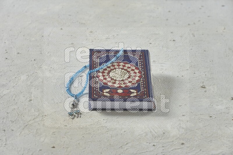 Quran with a prayer beads on white background