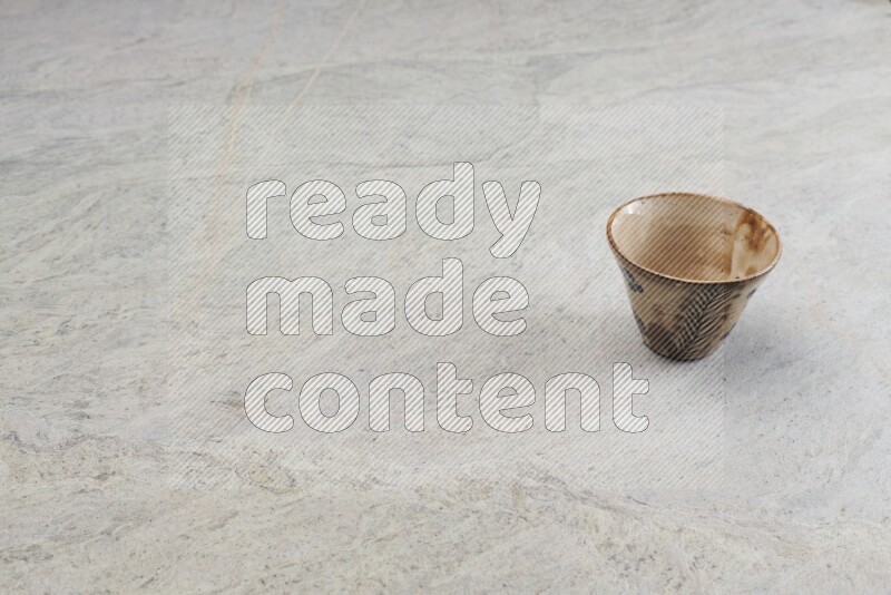 A multicolored pottery Cup on grey marble background