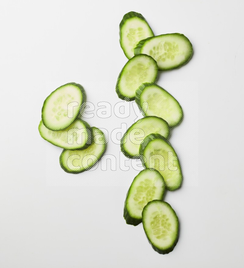 Multiple cucumber slices on white background
