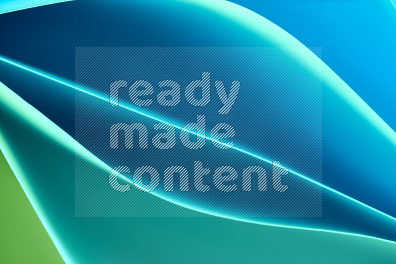 This image showcases an abstract paper art composition with paper curves in green and blue gradients created by colored light