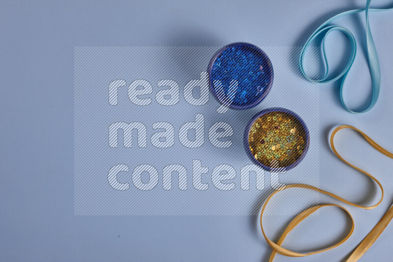 مجموعة من أدوات الخياطة والتفصيل صفراء وزرقاء اللون على خلفية زرقاء