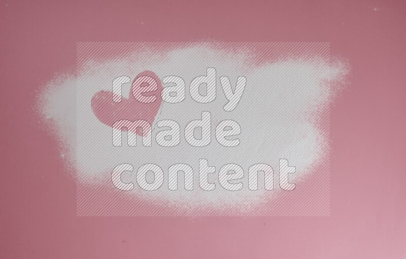 A heart drawn with powder on pink background