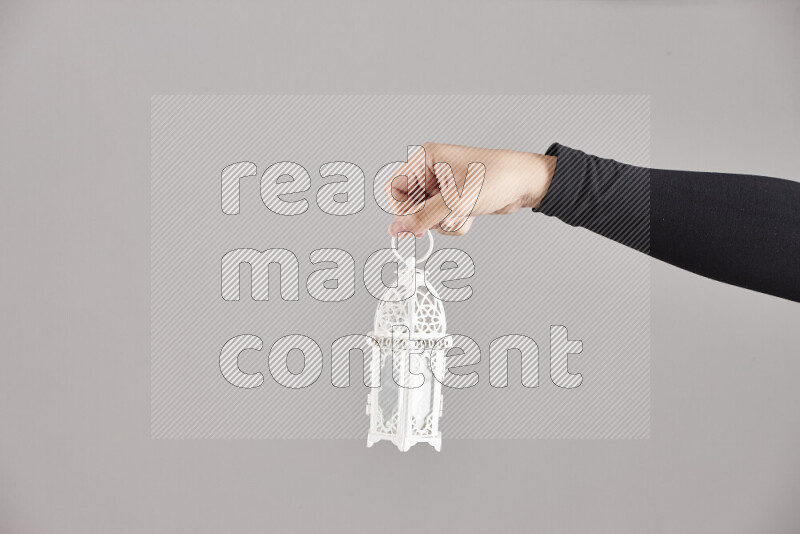 A woman in black abaya holding different ramadan lanterns in different positions