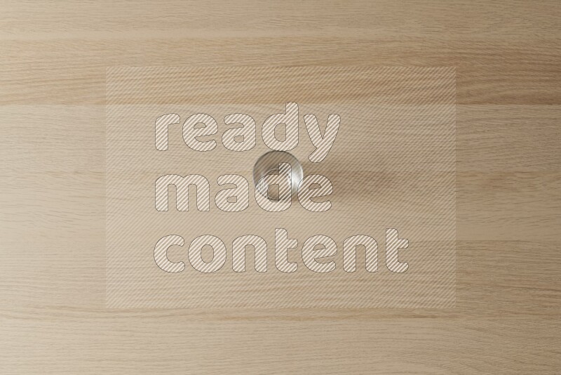 An empty glass cup on light wooden background