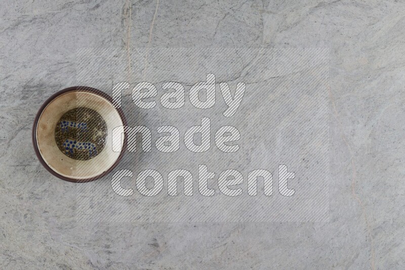 A decorative pottery plate on grey marble background