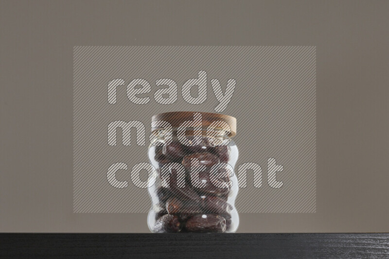 Dates in a glass jar on black background