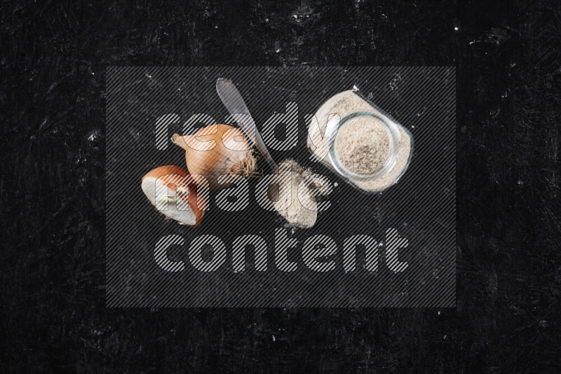 وعاء زجاجي ممتلئ ببودرة البصل علي خلفية سوداء