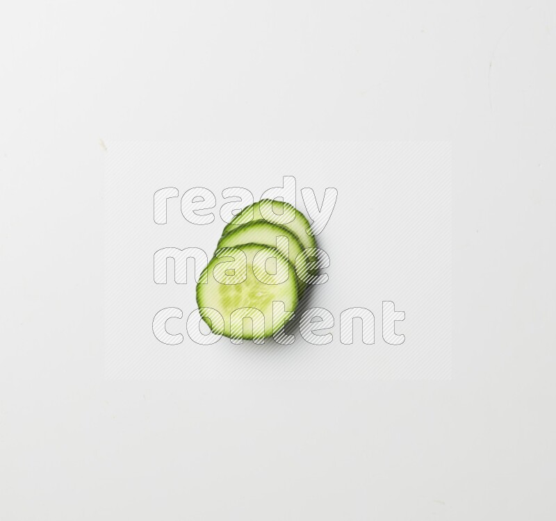 three cucumber slices on white background