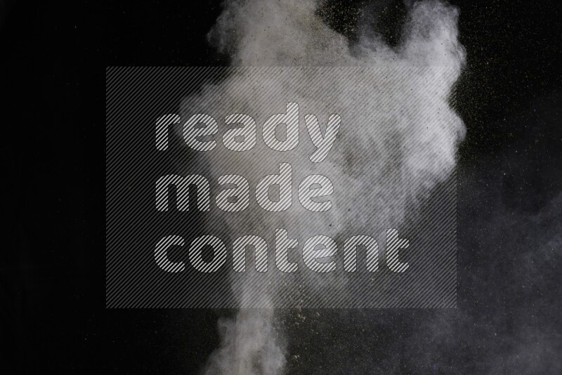 A side view of brown powder explosion on black background