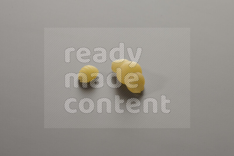 Shells pasta with other types of pasta on grey background