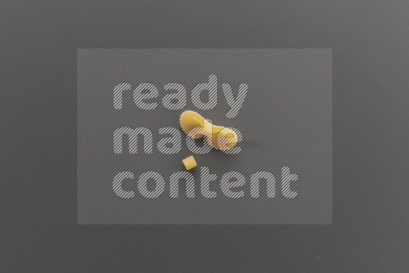 Small rings pasta with other types of pasta on grey background