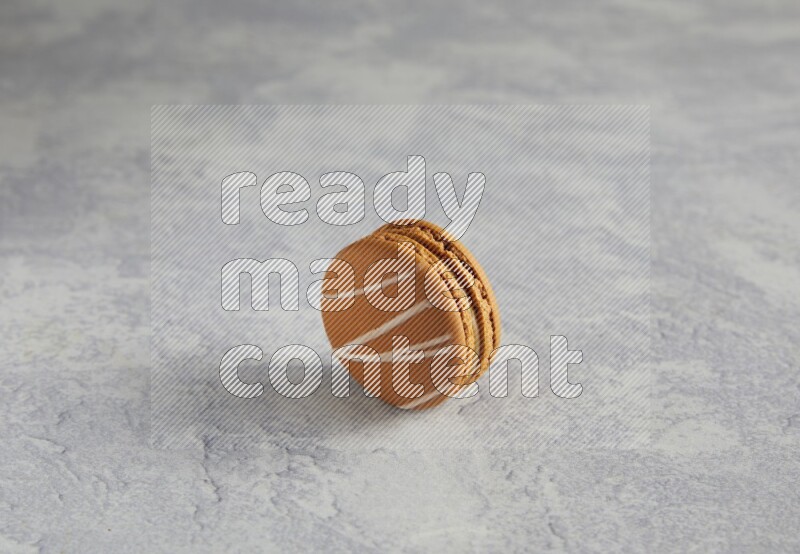 45º Shot of Brown Irish Cream macaron on white marble background