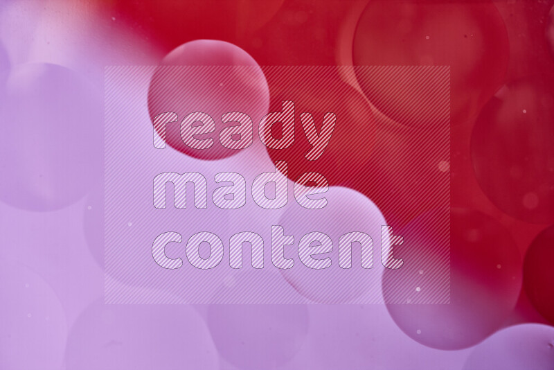 Close-ups of abstract oil bubbles on water surface in shades of red and pink