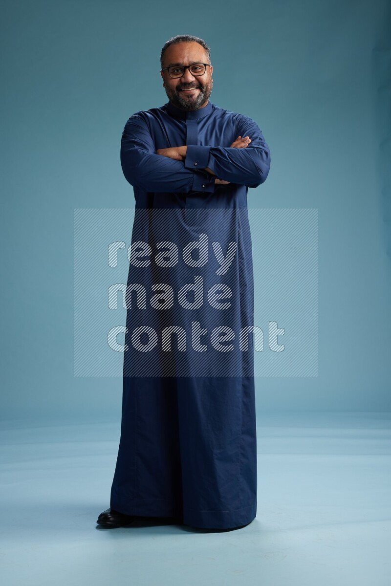 Saudi Man without shimag Standing Interacting with the camera on blue background