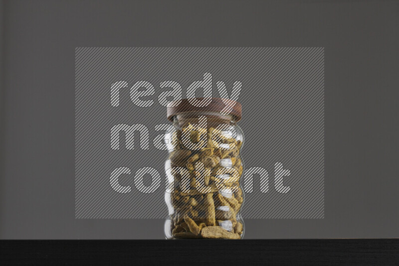 Turmeric in a glass jar on black background