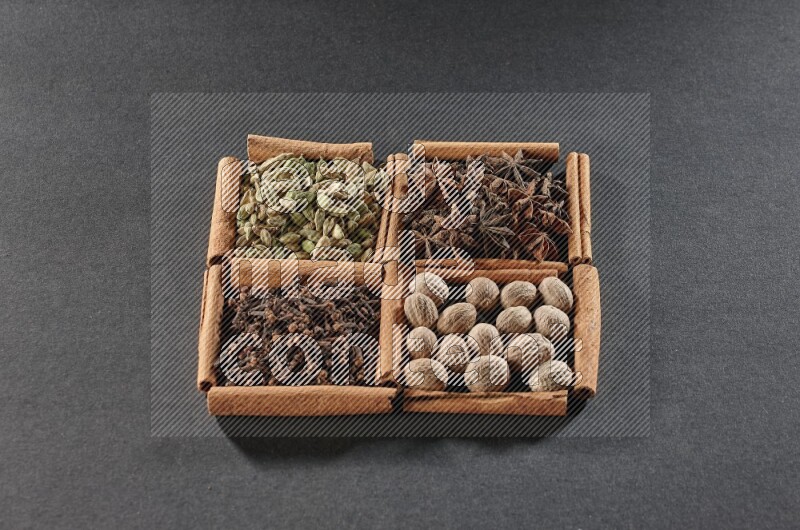 4 squares of cinnamon sticks full of cardamom, star anise, nutmegs and cloves on black flooring