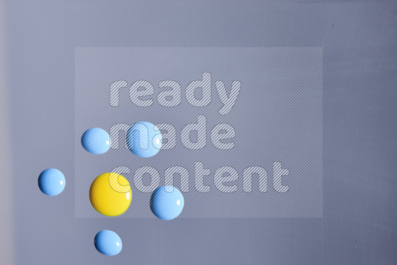 Close-ups of abstract blue and yellow paint droplets on the surface