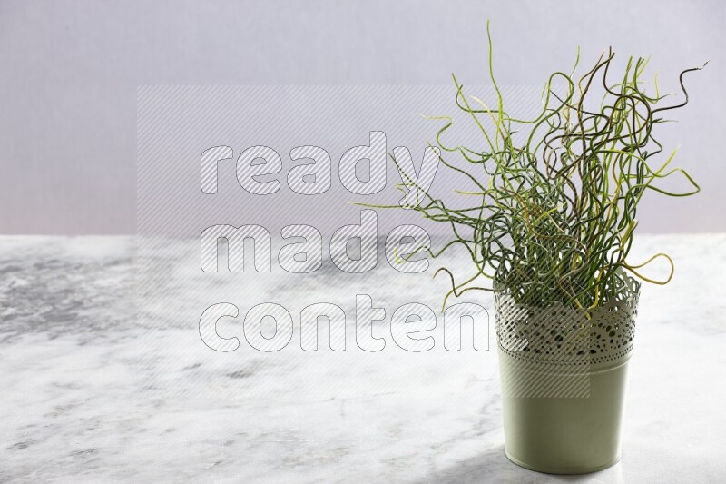 Artificial plant in green decorative pot on grey marble background