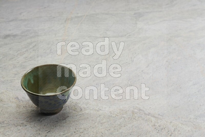 A multicolored pottery bowl on grey marble background