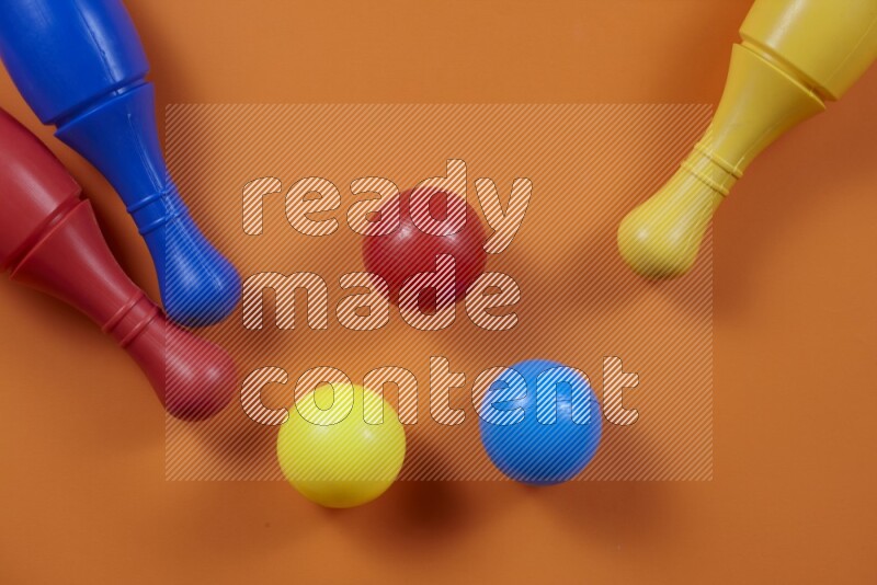 Plastic bowling pins with balls on different colored backgrounds (kids toys)
