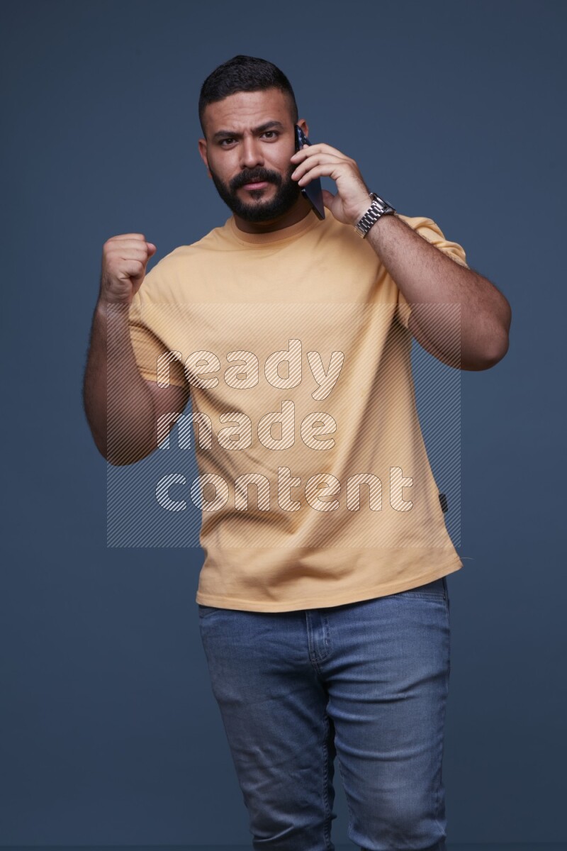 A man Calling on Blue Background wearing Orange T-shirt