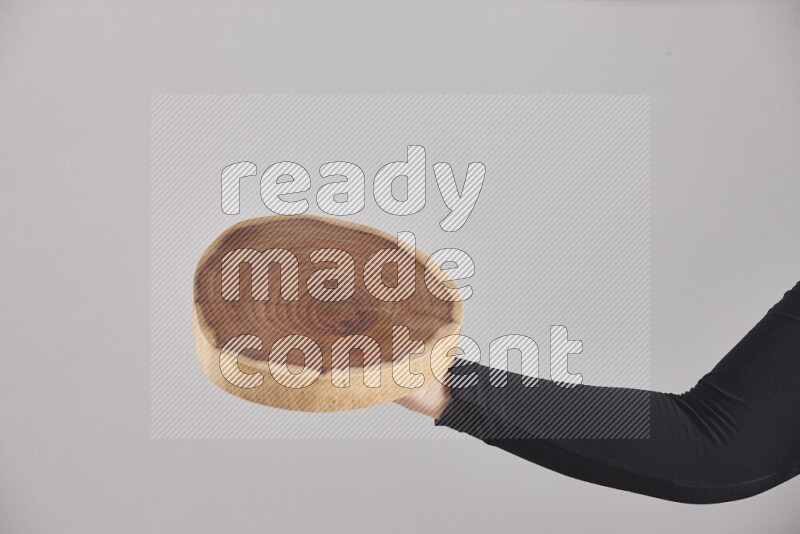 A woman in black abaya holding different wooden essentials in different positions