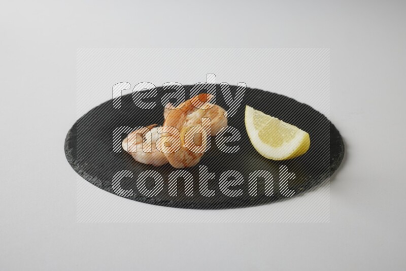 three grilled shrimp  on a black slate direct  on a white back ground