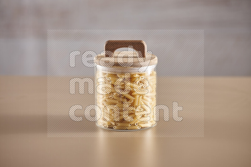 Raw pasta in glass jars on beige background