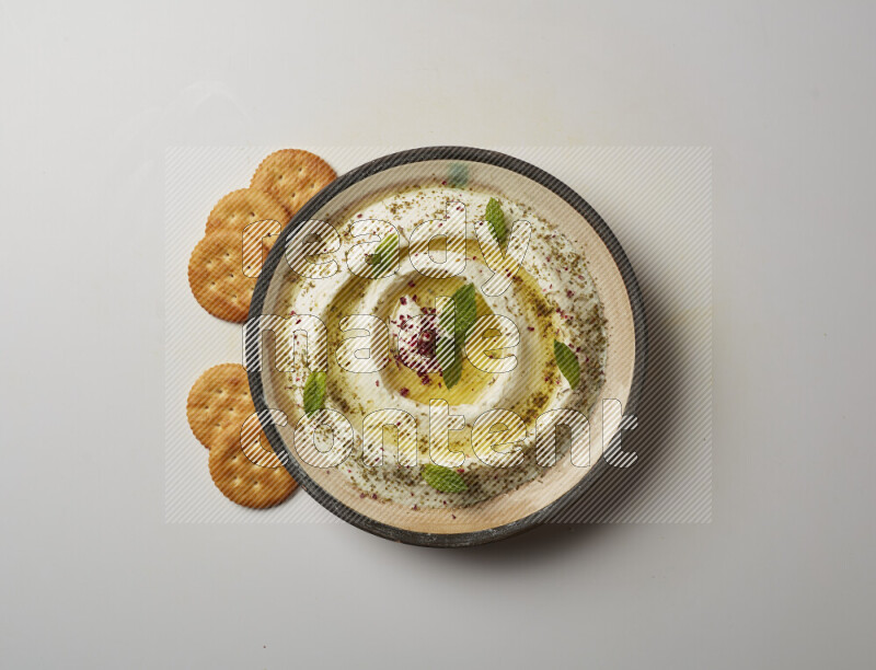 Lebnah garnished with zaater, mint & sumak in a pottery plate on a white background