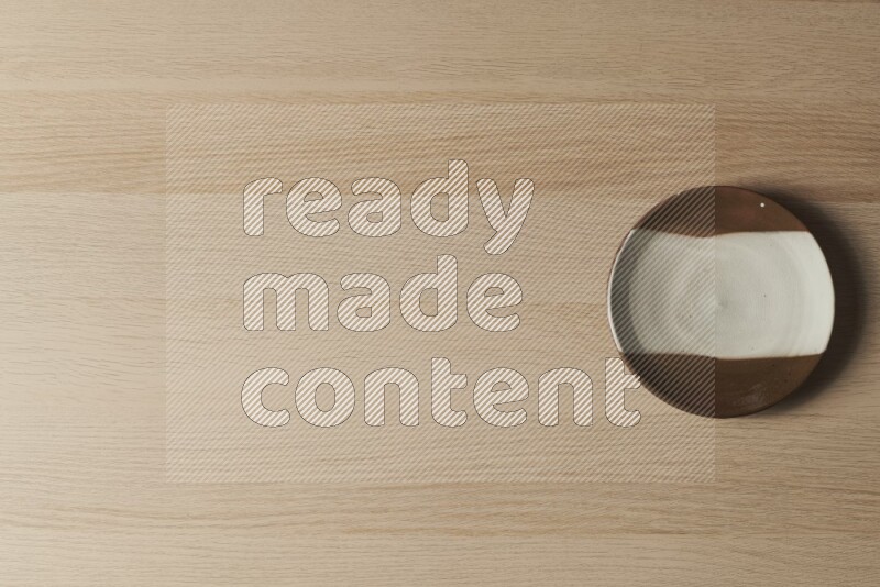 صحن فخاري متعدد الألوان على خلفية خشبية فاتحة