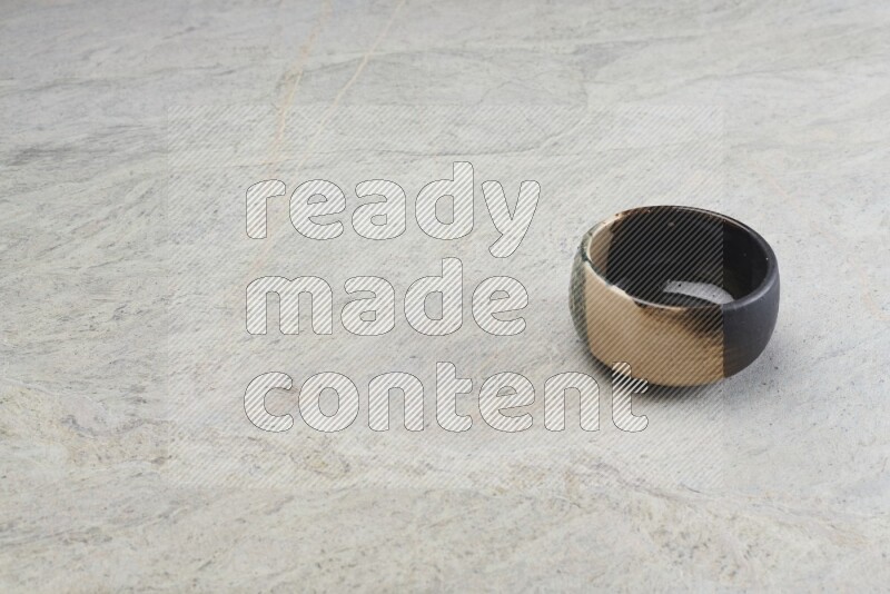 A multicolored pottery bowl on grey marble background
