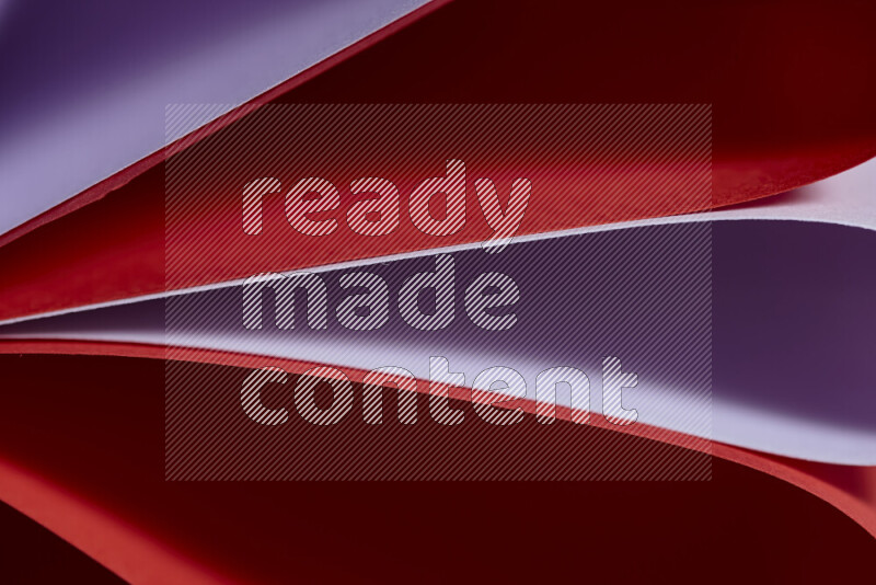 An abstract art showing purple and red paper sheets arranged in an overlapping curves