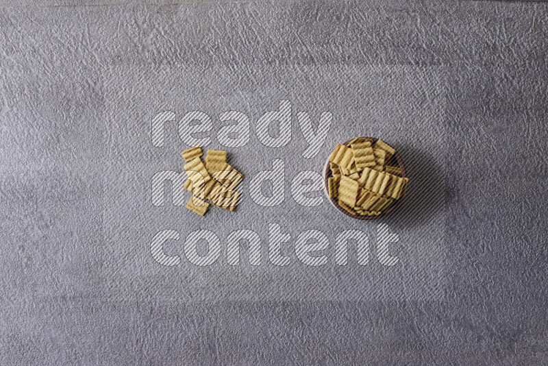 Assorted snacks in pottery bowls on grey background