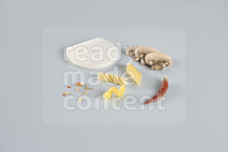 Raw pasta with different ingredients such as cherry tomatoes, garlic, onions, red chilis, black pepper, white pepper, bay laurel leaves, rosemary, cardamom and mushrooms on light blue background