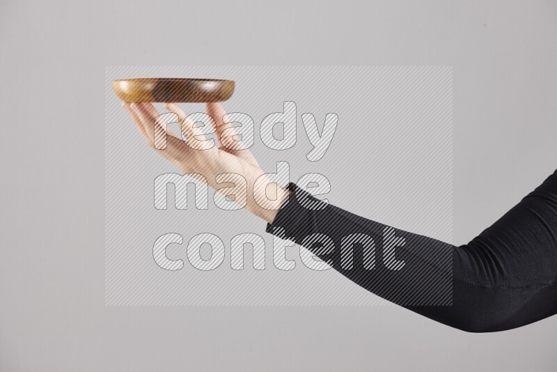 امرأة ترتدي عباءة سوداء تحمل أدوات خشبية مختلفة في أوضاع متعددة