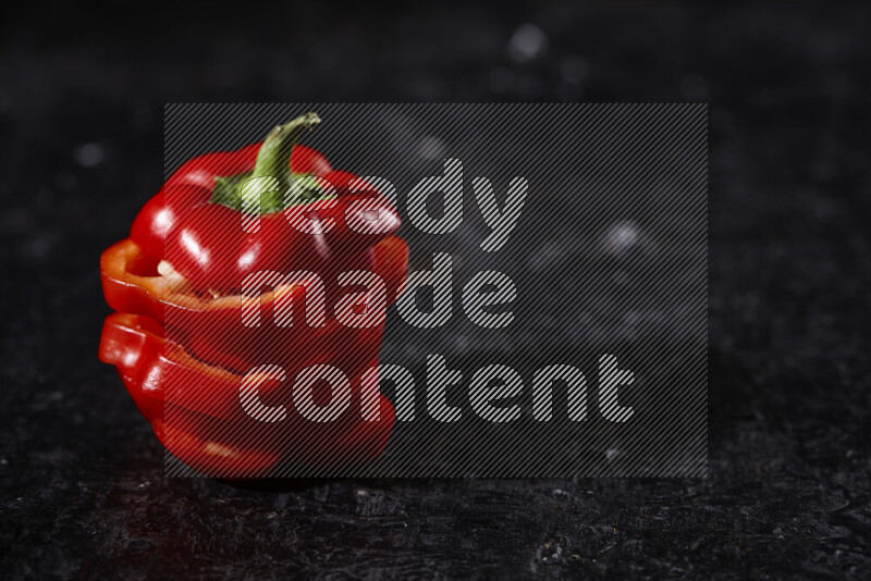 Red bell pepper slices on black background