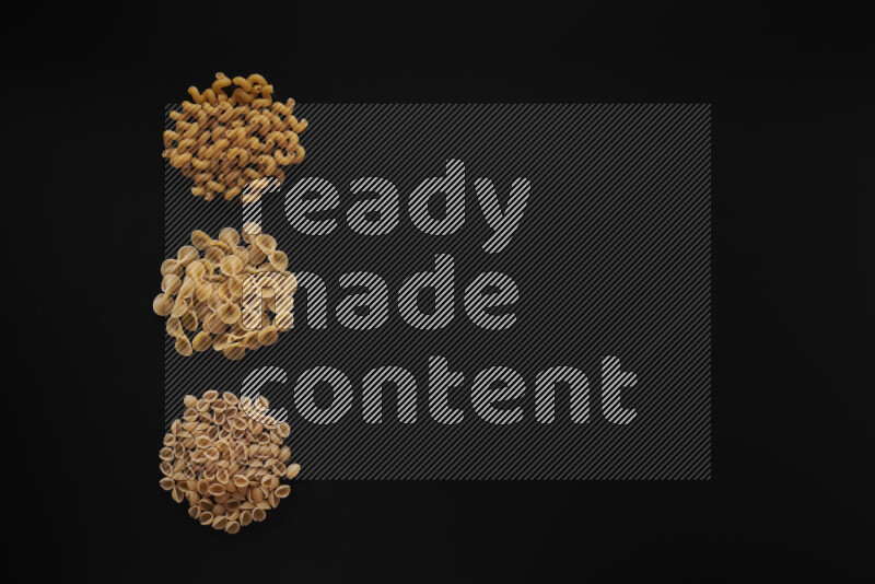 Different pasta types in 3 bunches on black background
