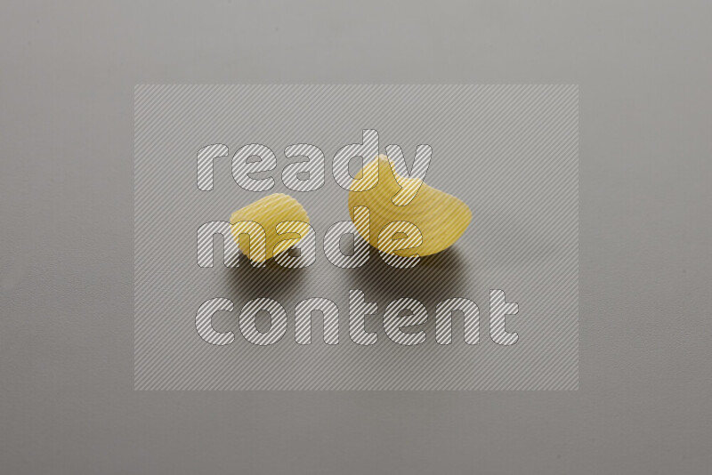 Big rings pasta with other types of pasta on grey background