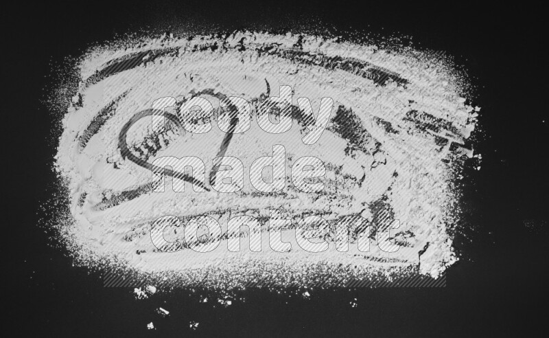 A heart drawn with powder on black background