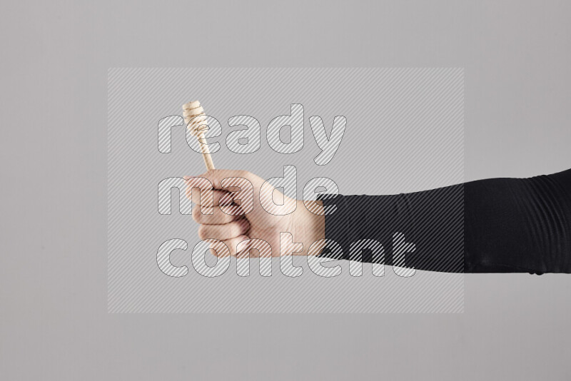 A woman in black abaya holding different wooden essentials in different positions