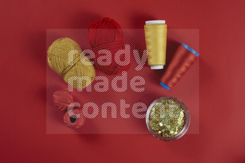 A yellow collection of sewing and tailoring tools arranged on a red background