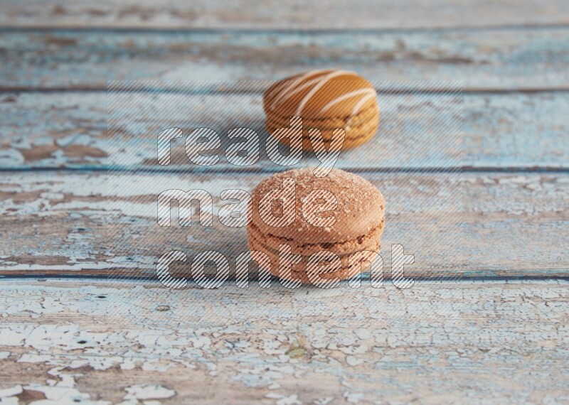 45º Shot of of two assorted Brown Irish Cream, and Brown Hazelnuts macarons  on light blue background