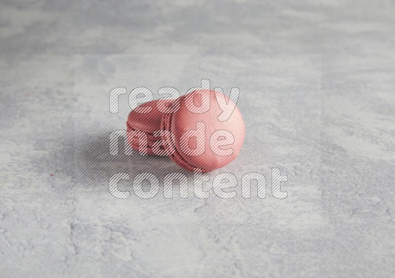 45º Shot of two Pink Raspberry macarons  on white  marble background