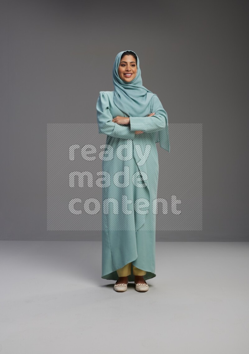 Saudi Woman wearing Abaya standing with crossed arms on Gray background