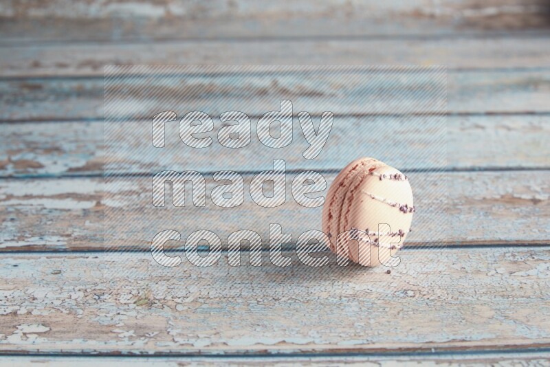 45º Shot of pink orange blossom macaron on light blue wooden background